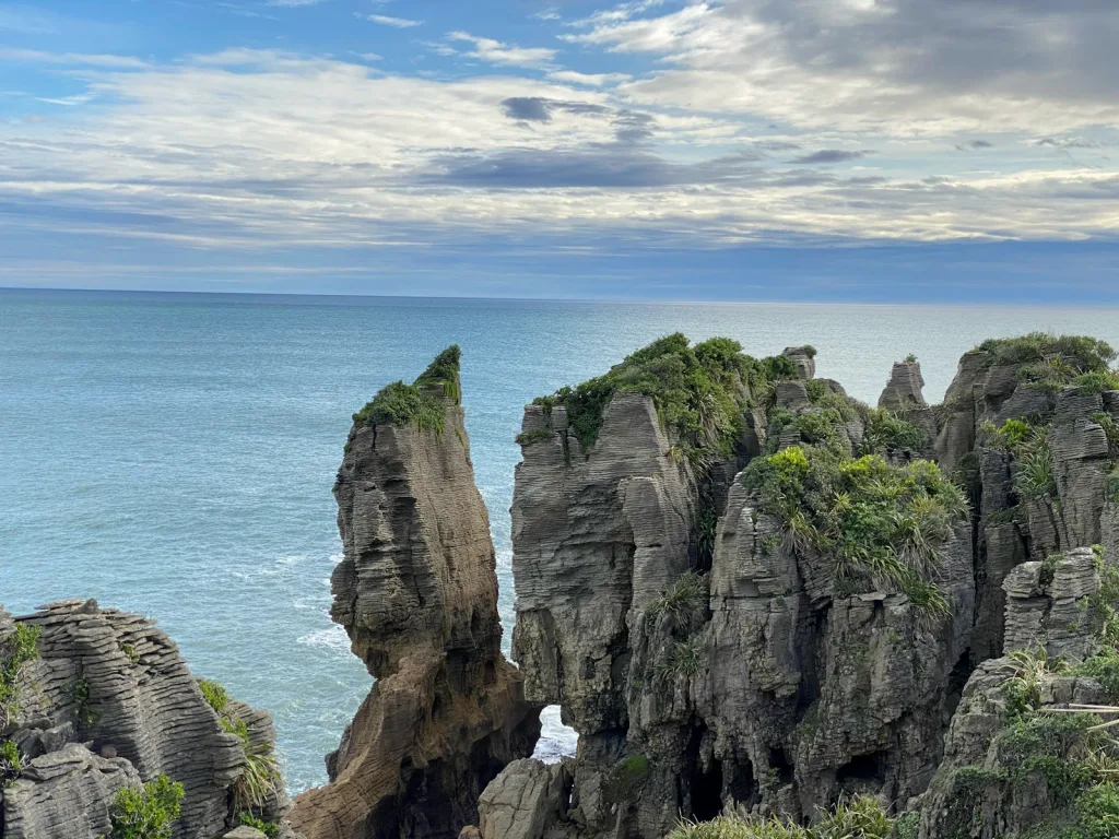 brown rocky mountain beside blue sea under blue sky during daytime