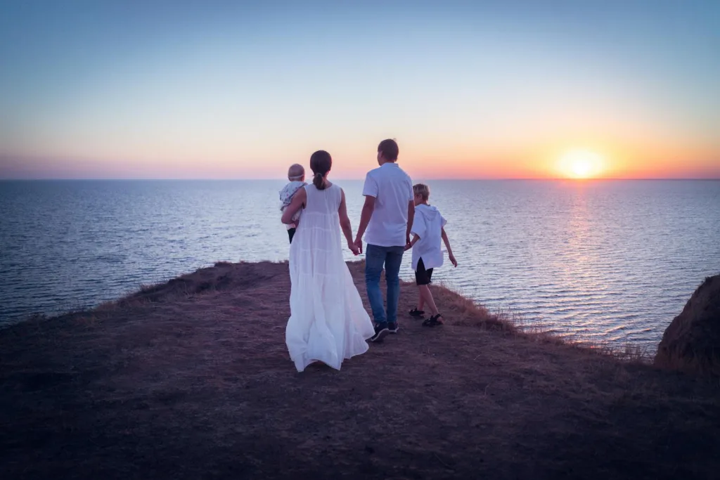 Back View of a Family Standing near the Cliff during Golden Hour