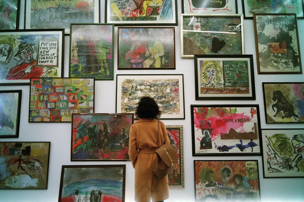 a woman standing in front of a wall covered in pictures